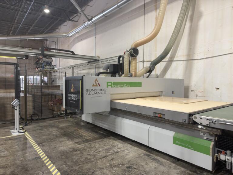 Biesse Rover A CNC router with a panel loaded on the vacuum table, branded Sunshine Alliance guard | Sunshine Alliance, Deerfield Beach FL