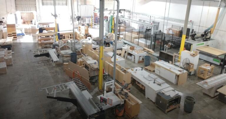 Cabinet factory floor with production machinery and assembled cabinet boxes staged for finishing | Sunshine Alliance, Deerfield Beach FL